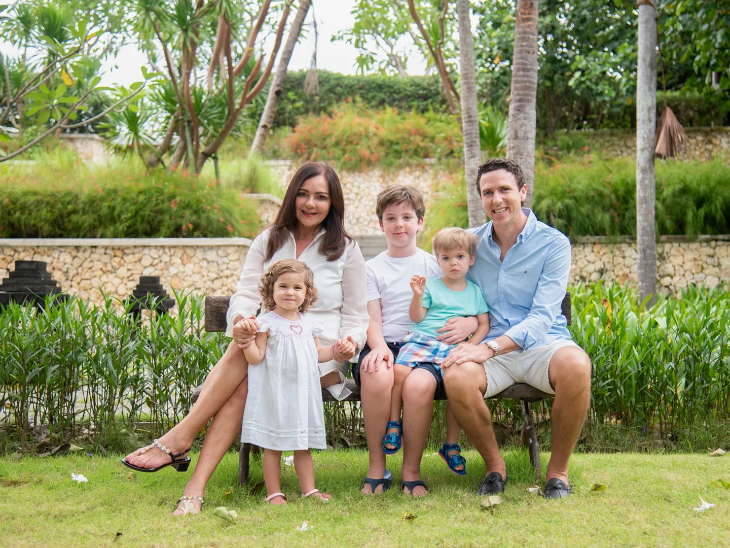 A family sitting together in a tropical Bali garden