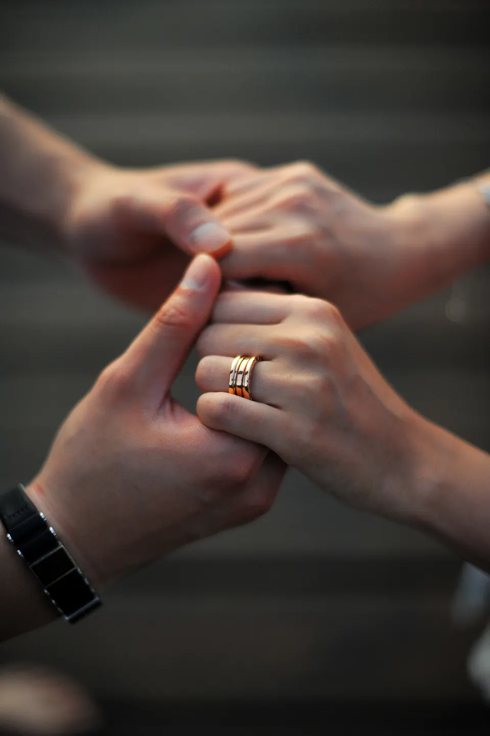 Close-up of a couple holding hands and an engagement ring